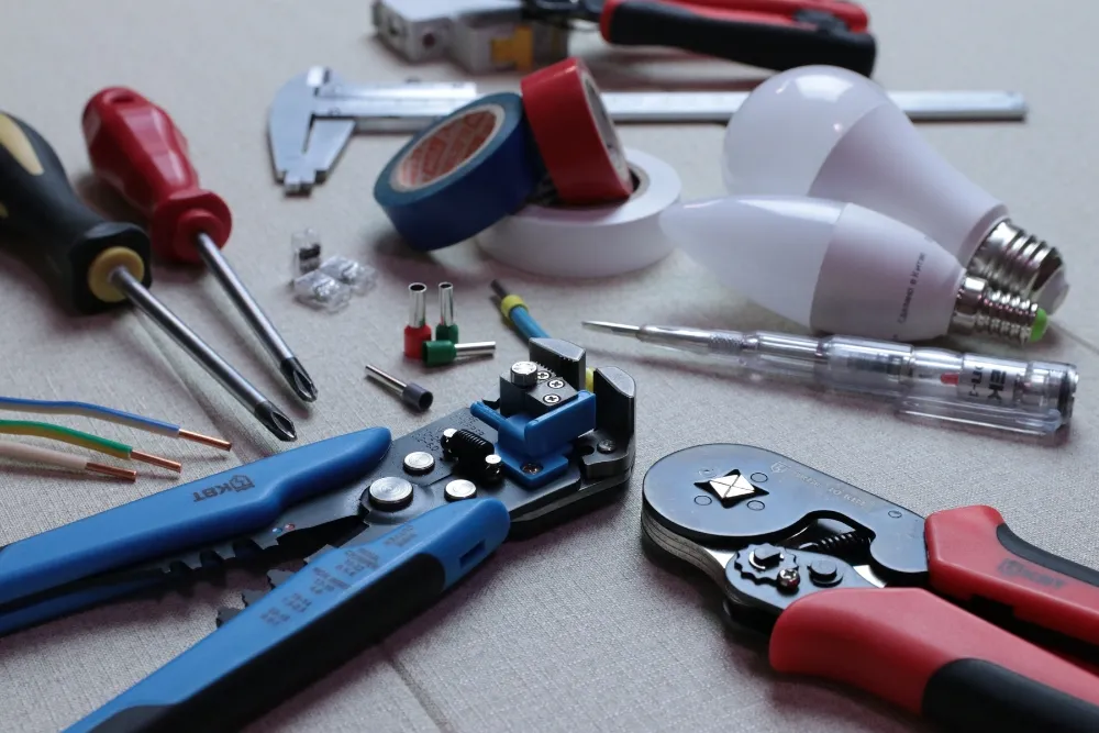 Various tools for appliance repair service, including screwdrivers, wire strippers, and light bulbs.